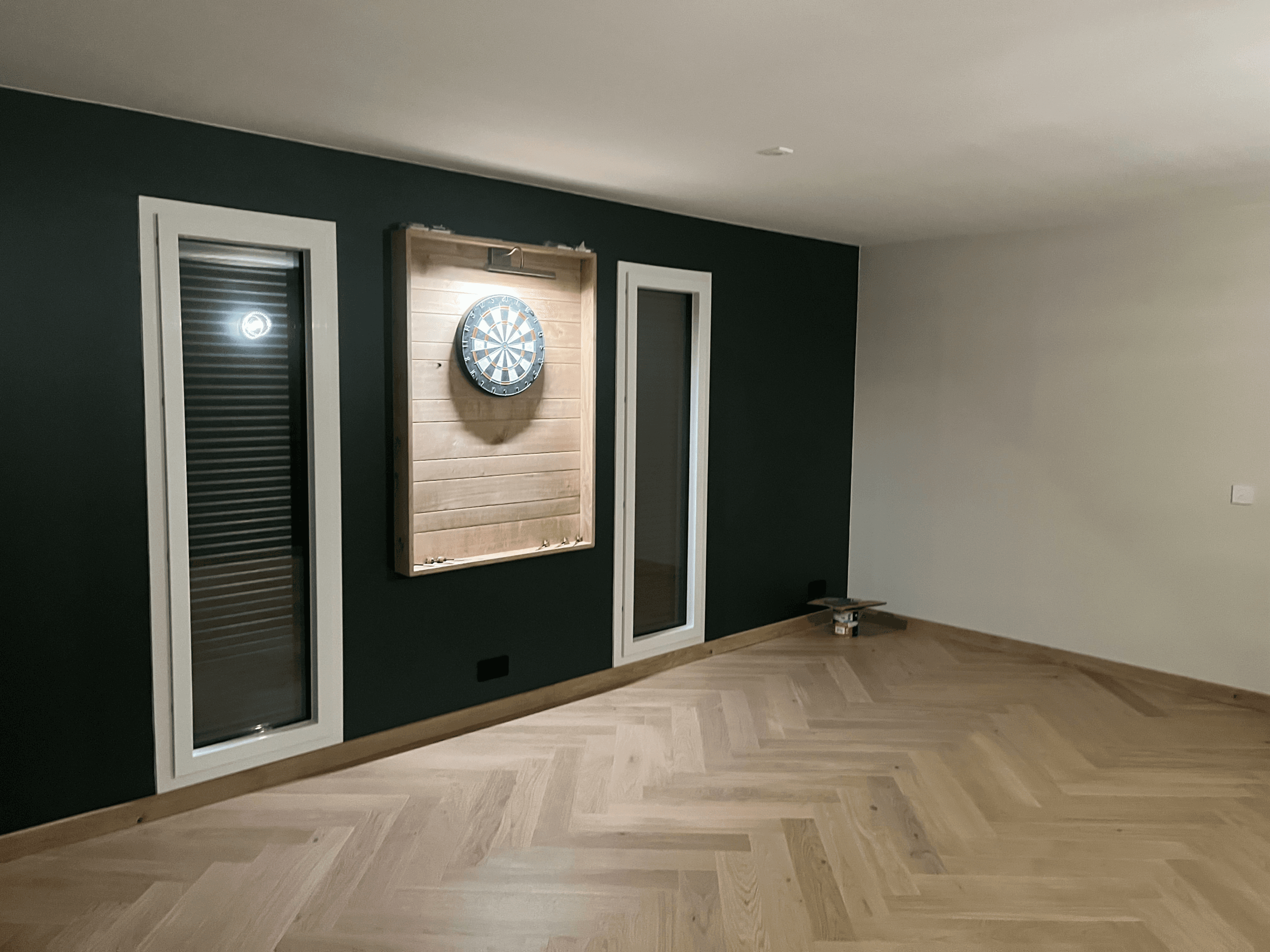 Pièce aménagée avec volets roulants sur mesure et parquet chevrons par Menuiserie Charron